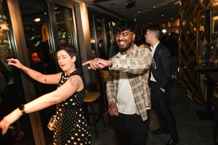 Guests dancing together near the bar.