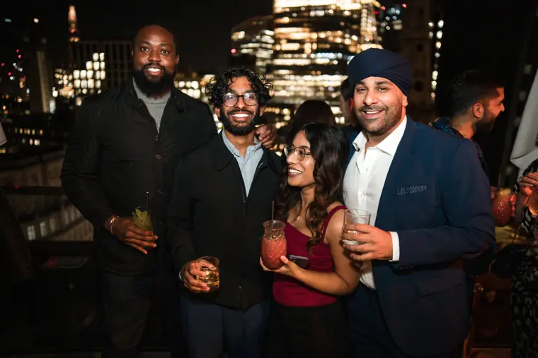 Four attendees posing together at the evening event.