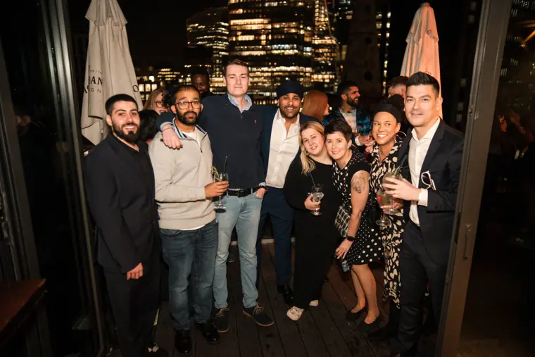 Guests posing together in the warm-lit venue.