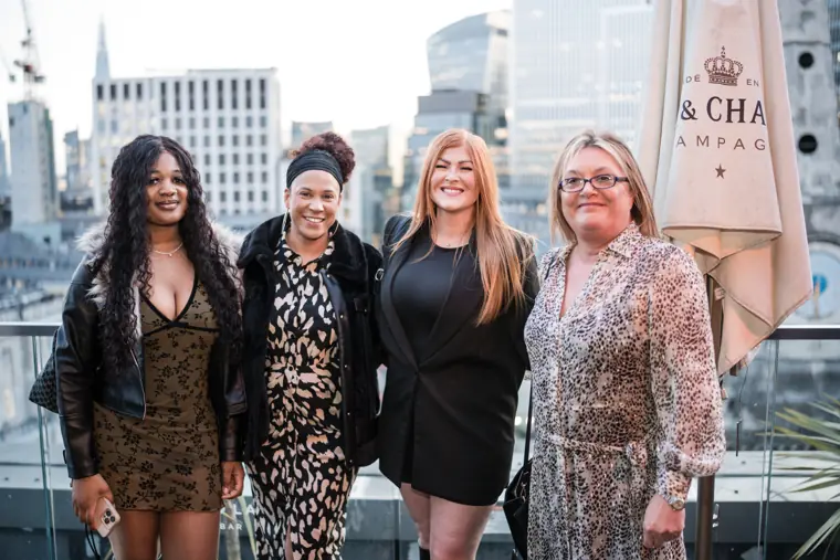 Four women posing together on the terrace before sunset.