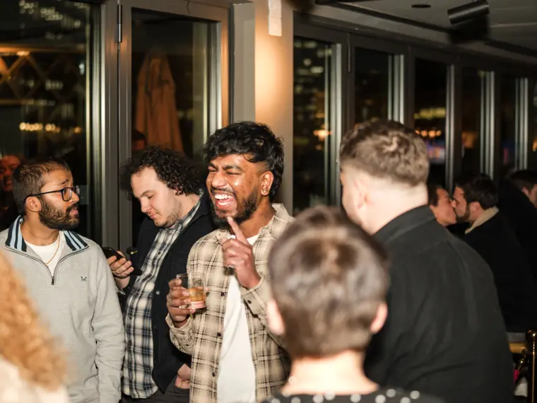 A group of guests smiling during an animated conversation.