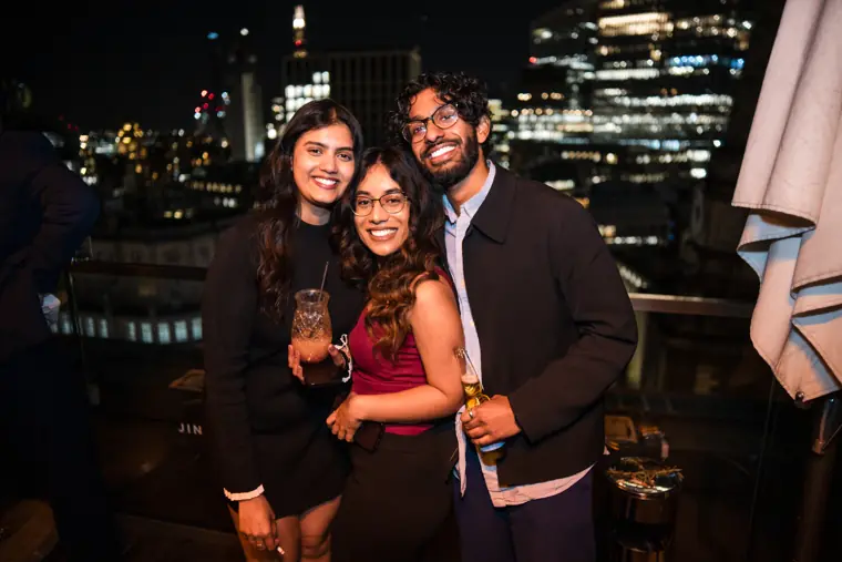 A woman in red posing with two colleagues.