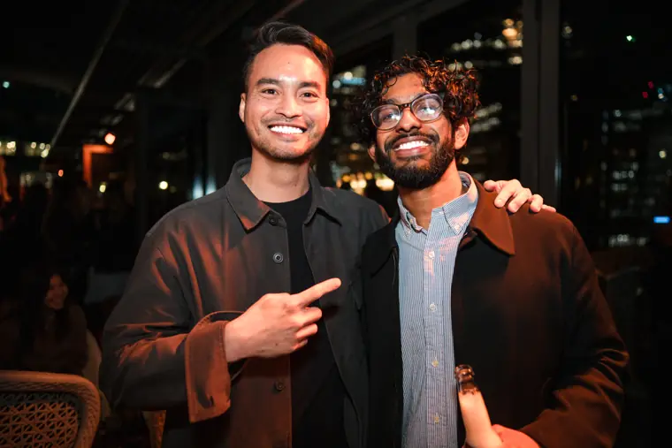 Two colleagues smiling for a portrait at the event.