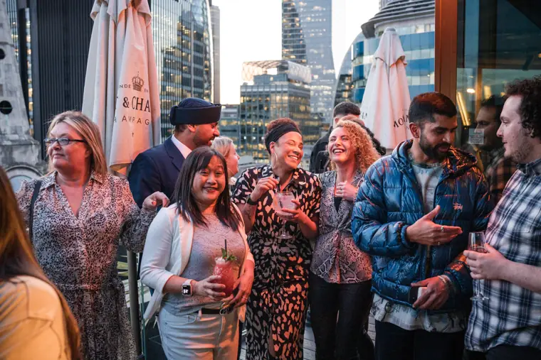 A group of guests raising drinks on the rooftop.
