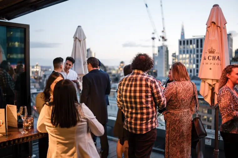 Guests arriving on the rooftop terrace at dusk.