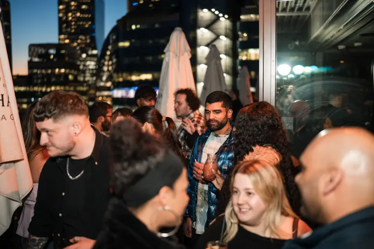 Guests filling the rooftop area at night.
