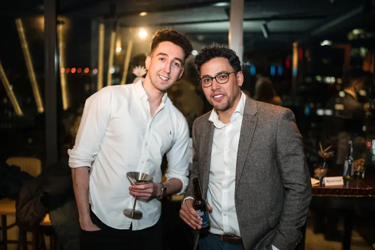 Two guests posing together with drinks.