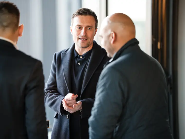 Three colleagues talking by the windows.
