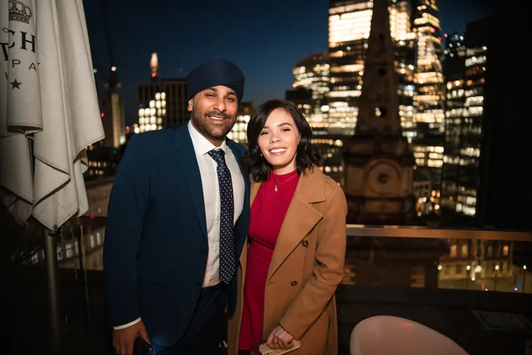 Two guests posing together against the night skyline.