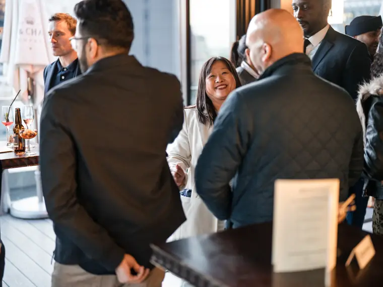 Guests talking around a table inside the venue.