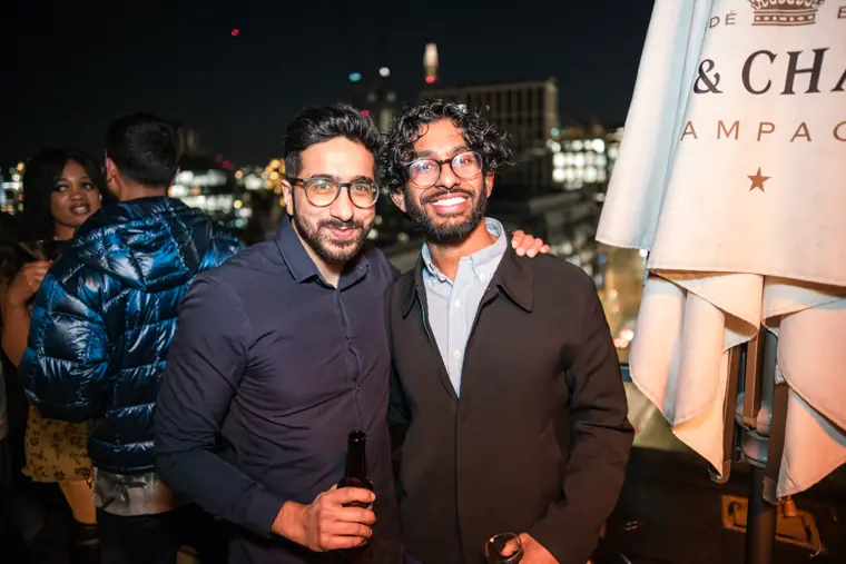 Two men smiling together during the evening reception.
