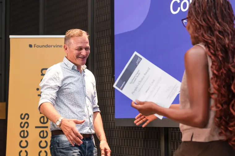 Founder receiving recognition at the showcase.