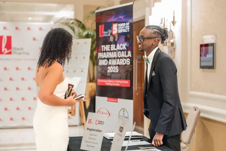 Attendee checking in at the registration table at the Black Pharma fifth anniversary gala.