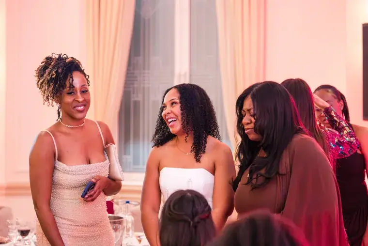 Group of women talking between dinner tables at the Black Pharma fifth anniversary gala.