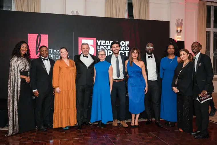 Group portrait in front of the anniversary stage screen at the Black Pharma fifth anniversary gala.