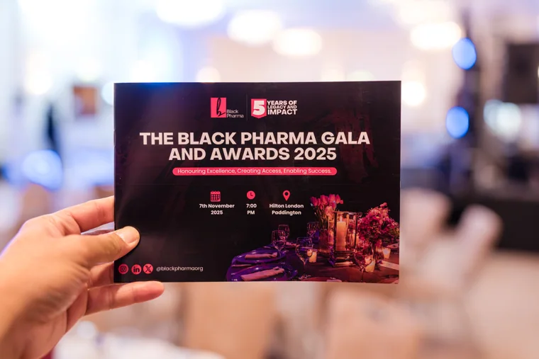 Guest holding the Black Pharma gala programme at the reception at the Black Pharma fifth anniversary gala.