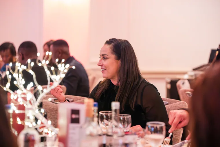 Guest smiling during a conversation at her table at the Black Pharma fifth anniversary gala.