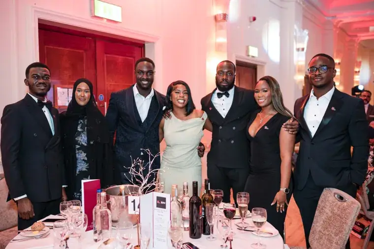 Guests posing together beside their gala dinner table at the Black Pharma fifth anniversary gala.