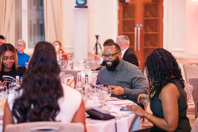 Guests settling around a gala dinner table at the Black Pharma fifth anniversary gala.
