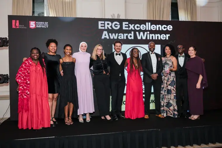 Large group celebrating an award on stage at the Black Pharma fifth anniversary gala.