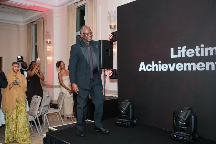 Lifetime Achievement award recipient walking across the stage at the Black Pharma fifth anniversary gala.
