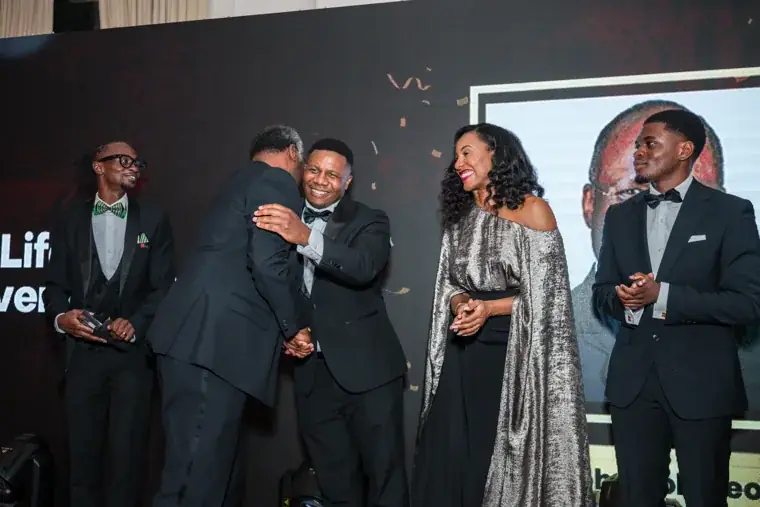 Presenter and award recipient embracing on stage at the Black Pharma fifth anniversary gala.