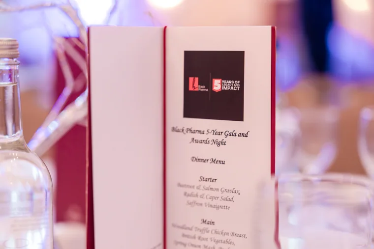 Printed dinner menu beside the Black Pharma anniversary programme at the Black Pharma fifth anniversary gala.