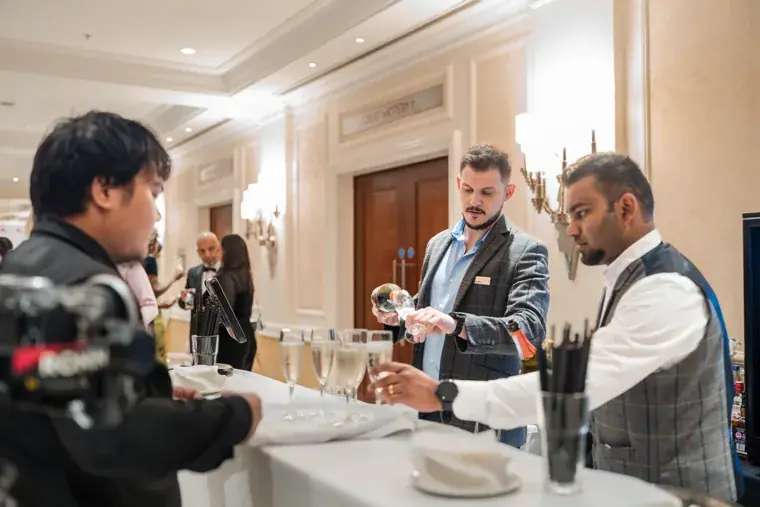 Server offering drinks to guests in the foyer at the Black Pharma fifth anniversary gala.