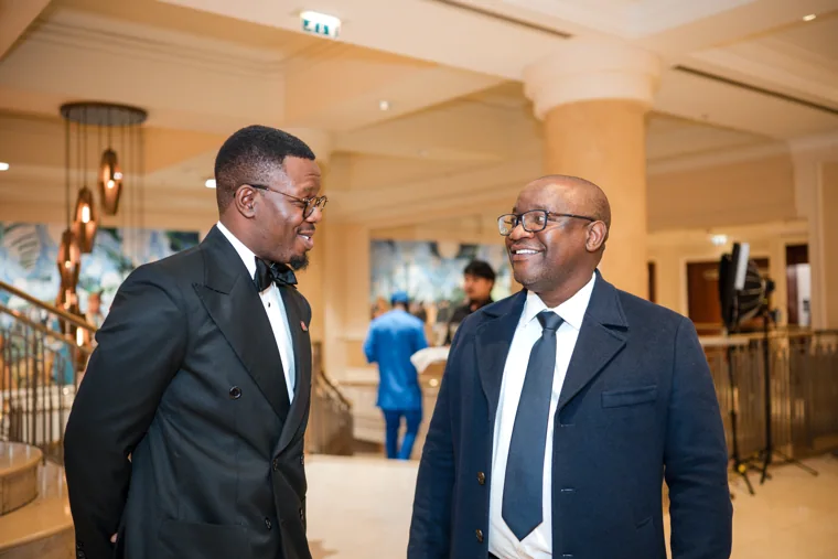 Two guests in conversation beside the hotel staircase at the Black Pharma fifth anniversary gala.