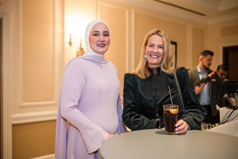 Two guests smiling together with a drink at the gala at the Black Pharma fifth anniversary gala.