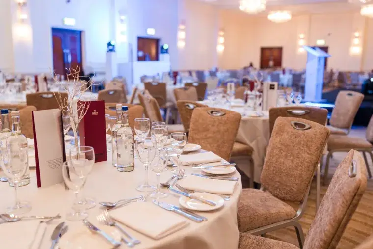 Wide view of round dining tables in the ballroom before guests arrive at the Black Pharma fifth anniversary gala.