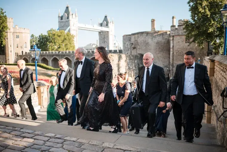 A group of guests arriving up the sunlit steps at the Chambers High Net Worth Awards 2025.