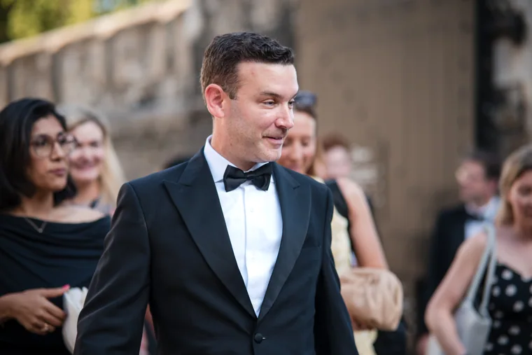 A guest in a bow tie listening during an outdoor conversation at the Chambers High Net Worth Awards 2025.