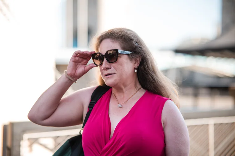 A guest in a pink dress adjusting her sunglasses at the Chambers High Net Worth Awards 2025.