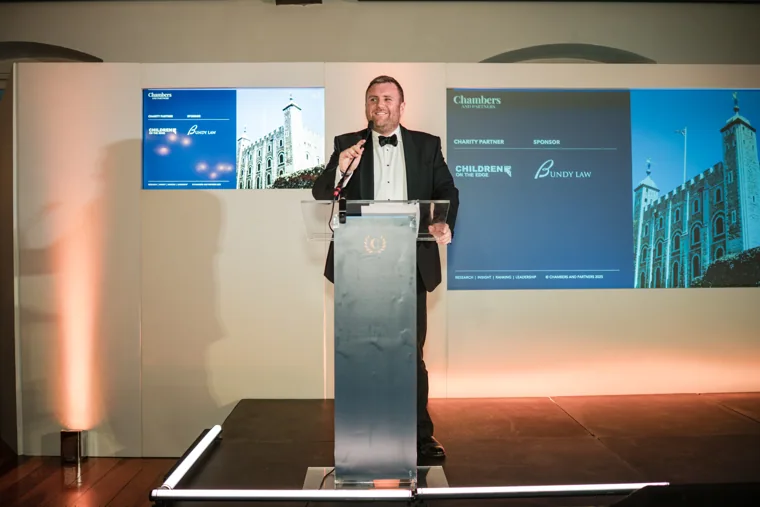 A speaker presenting from the lectern during the awards ceremony at the Chambers High Net Worth Awards 2025.
