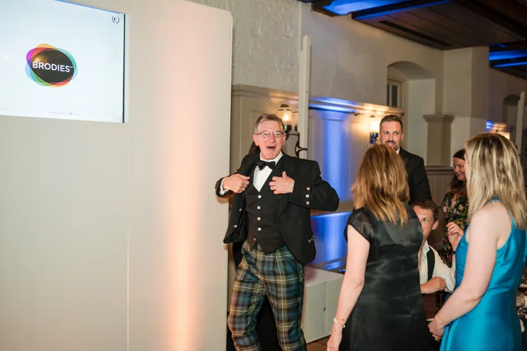 An award recipient speaking into a microphone on stage at the Chambers High Net Worth Awards 2025.