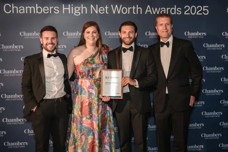 Award recipients holding a silver trophy at the Chambers photo wall at the Chambers High Net Worth Awards 2025.