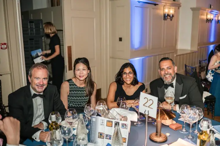 Four guests smiling together at their dinner table at the Chambers High Net Worth Awards 2025.