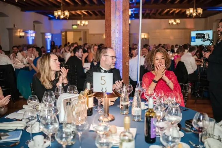 Guests applauding at a dinner table at the Chambers High Net Worth Awards 2025.