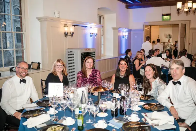 Guests posing together around a dinner table at the Chambers High Net Worth Awards 2025.