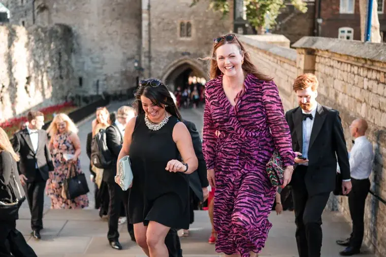 Guests smiling as they climb the stone steps at the Chambers High Net Worth Awards 2025.