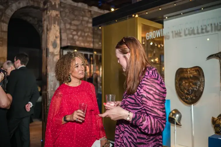Guests talking beside an exhibition display at the Chambers High Net Worth Awards 2025.