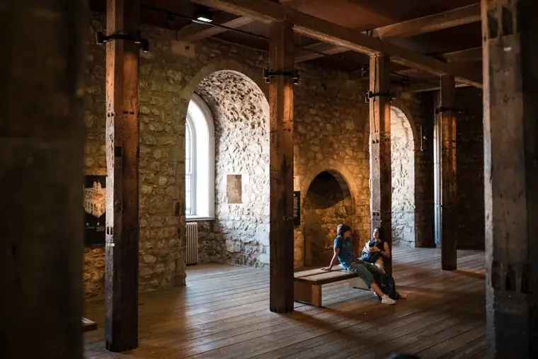 Sunlight falling through an arched window in the historic stone interior at the Chambers High Net Worth Awards 2025.