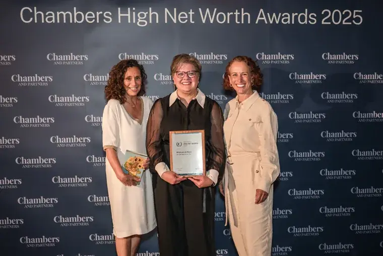 Three award recipients posing together at the branded photo wall at the Chambers High Net Worth Awards 2025.