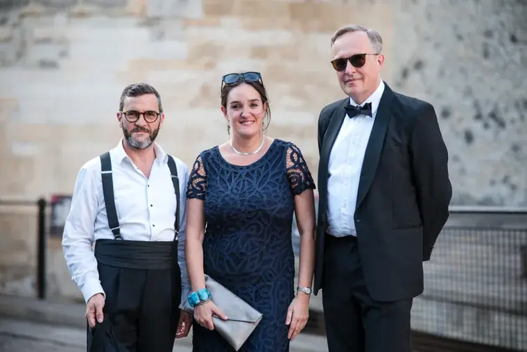 Three guests posing together beside a stone wall at the Chambers High Net Worth Awards 2025.