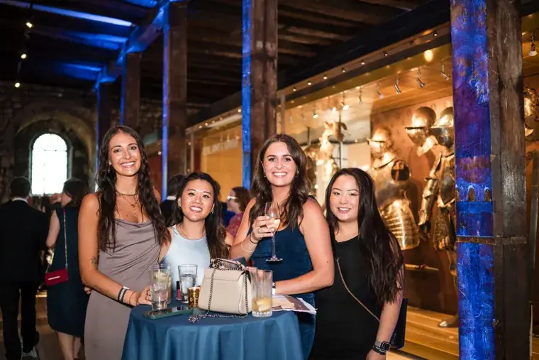 Three guests smiling together at a reception table at the Chambers High Net Worth Awards 2025.