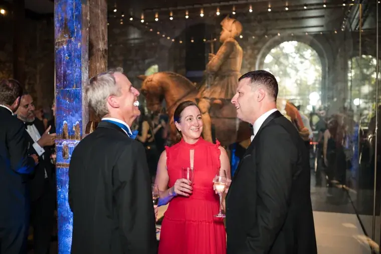 Three guests talking among the historic armour exhibits at the Chambers High Net Worth Awards 2025.