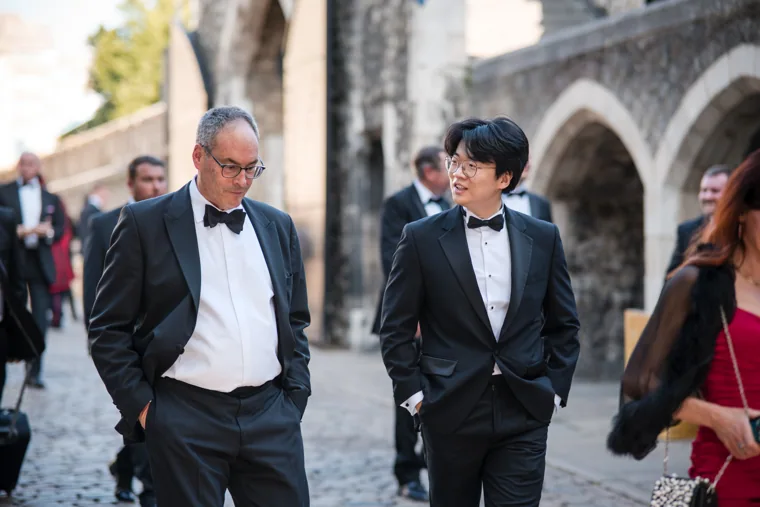 Two guests in black tie talking as they walk at the Chambers High Net Worth Awards 2025.