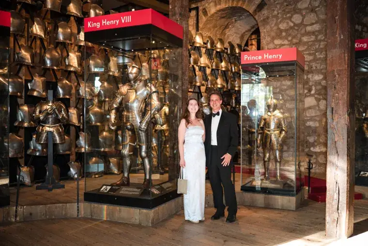 Two guests posing beside the armour exhibition at the Chambers High Net Worth Awards 2025.