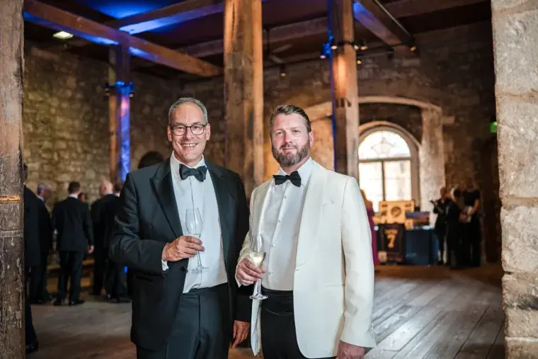 Two guests smiling together at the indoor reception at the Chambers High Net Worth Awards 2025.